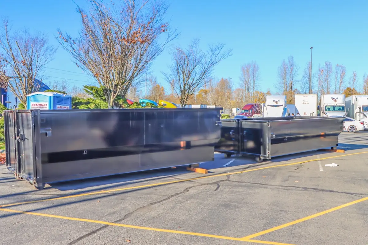 Professional dumpster rental service with roll-off container on residential driveway in West York
